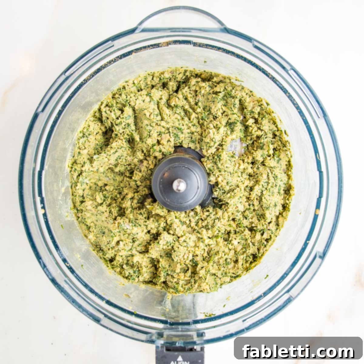 Ground herbs, seeds, chickpeas and tahini for falafel balls. The fully combined mixture of ground herbs, seeds, chickpeas, and tahini for falafel balls, now a coarse, greenish paste that will hold its shape perfectly.