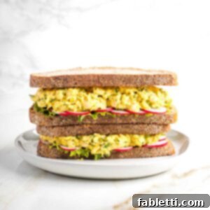 Creamy Vegan Chicken Salad 10 Vegan chicken salad sandwich with lettuce and sliced radishes on sourdough, stacked two high, ready to be eaten.