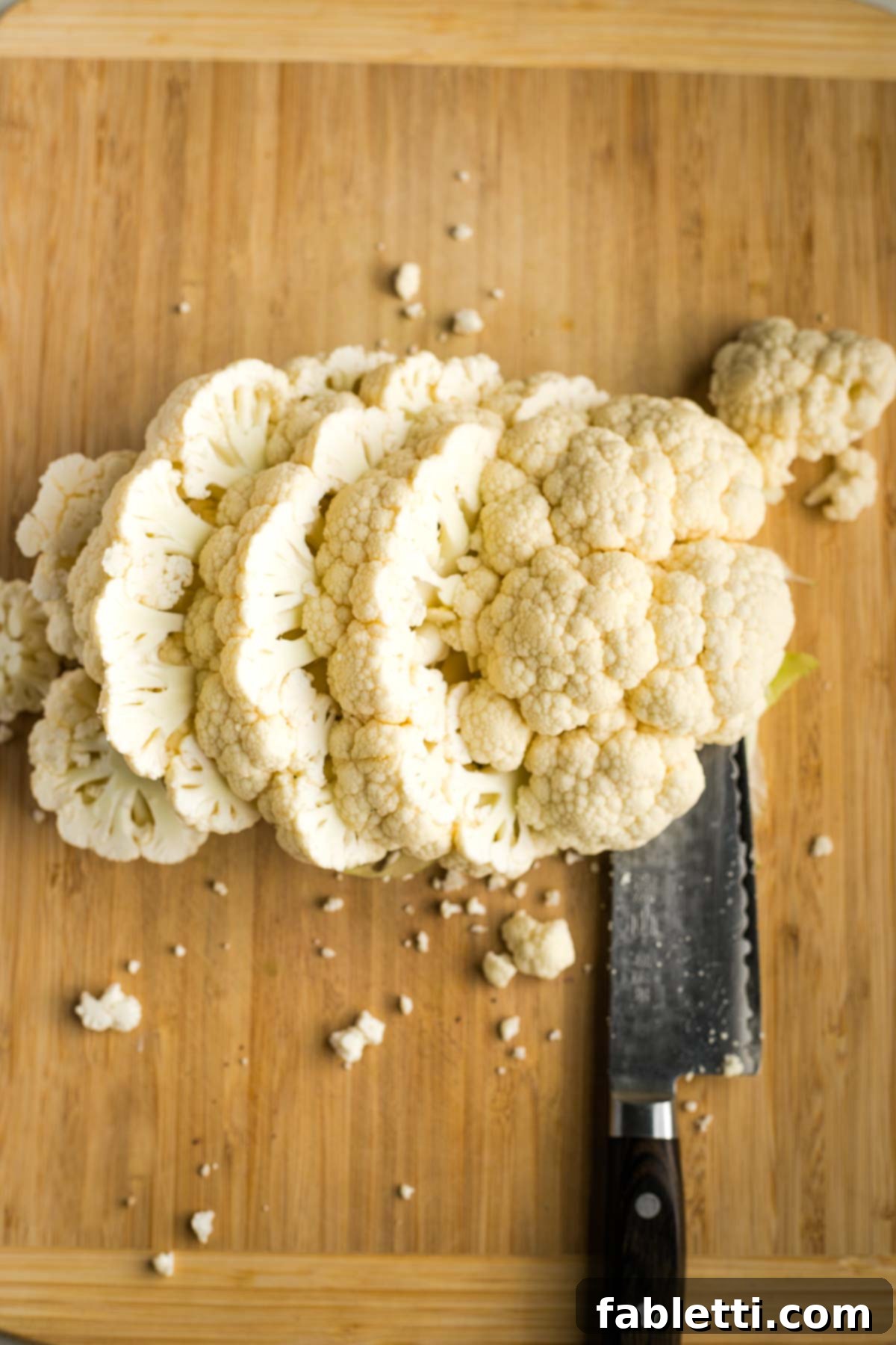 Golden Seared Cauliflower Steaks with Herbaceous Chimichurri 9 Sliced cauliflower steaks and florets on a cutting board.