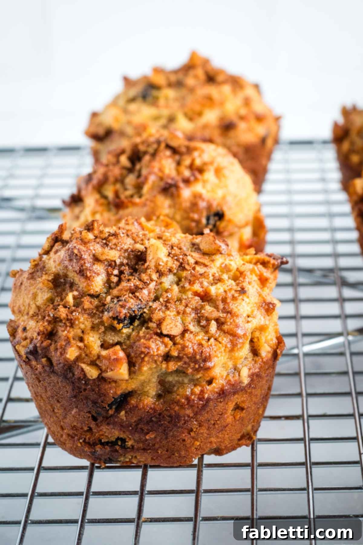 Delightful Gluten-Free Almond Carrot Muffins 16 Carrot muffin topped with walnuts and cinnamon, on a wire rack cooling.