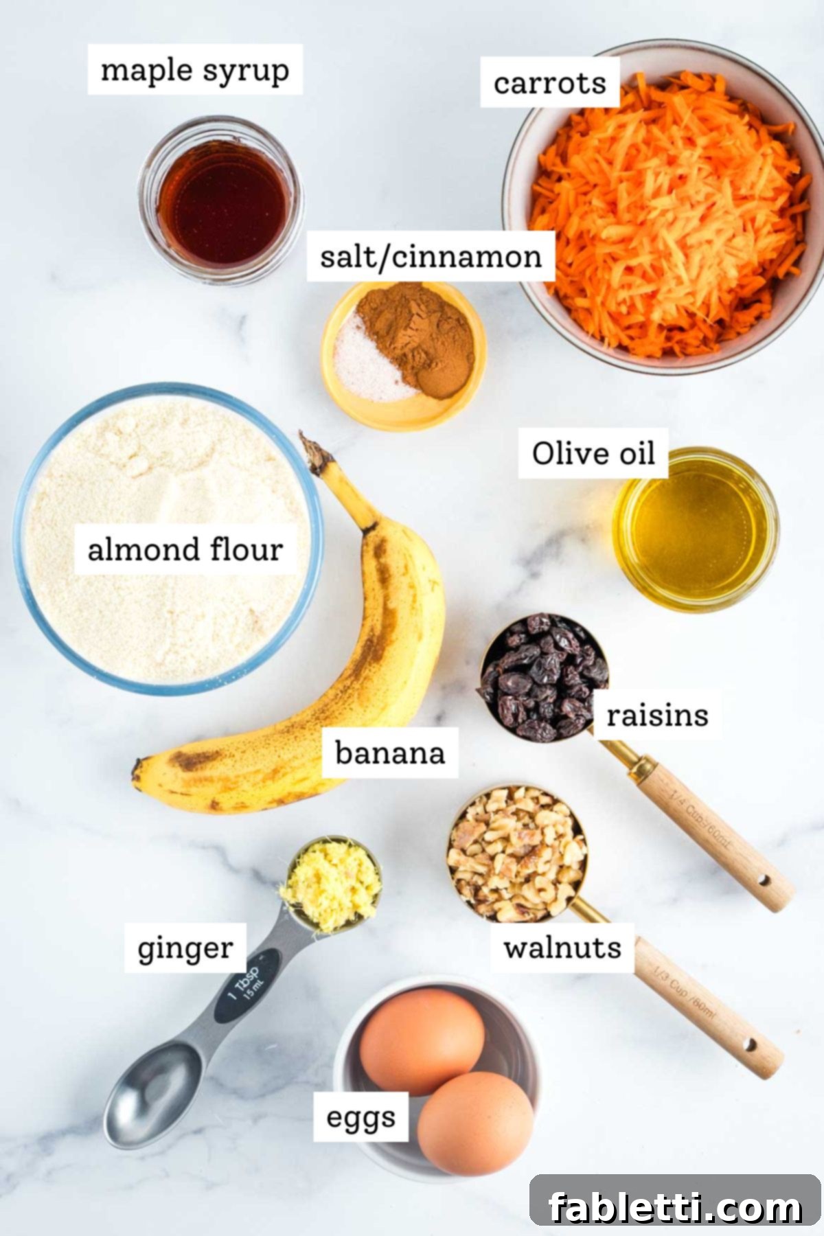 Delightful Gluten-Free Almond Carrot Muffins 3 Fresh ingredients laid out for making carrot muffins: bananas, eggs, olive oil, maple syrup, carrots, ginger, raisins, walnuts, cinnamon, and almond flour.