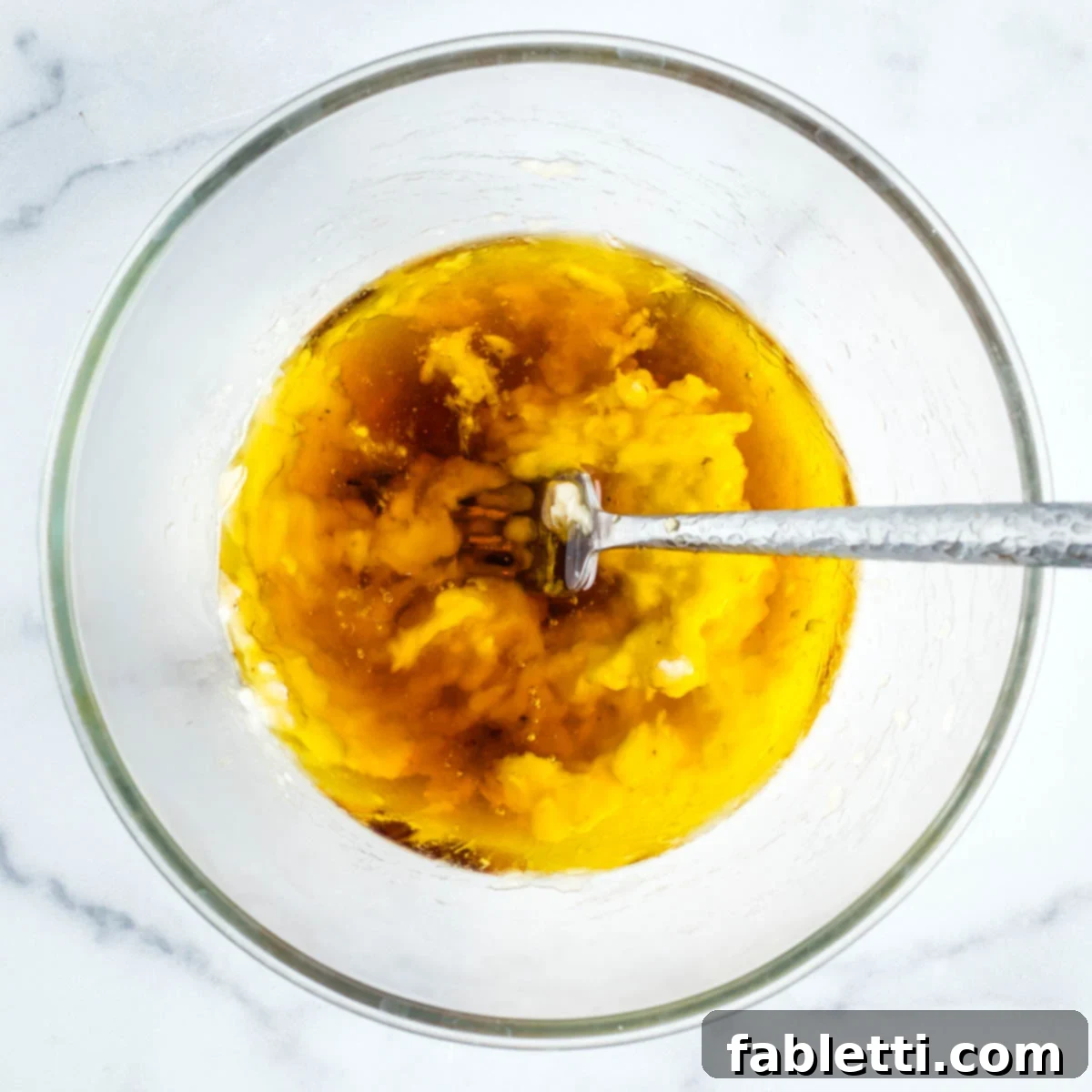 Delightful Gluten-Free Almond Carrot Muffins 5 Mixing mashed banana with olive oil and maple syrup in a bowl.