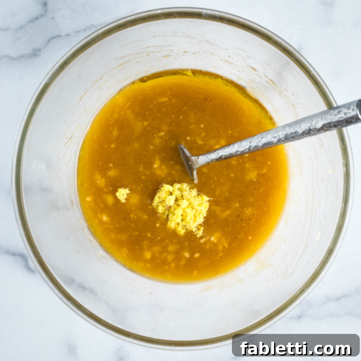 Delightful Gluten-Free Almond Carrot Muffins 6 Adding grated ginger to the wet muffin mixture.