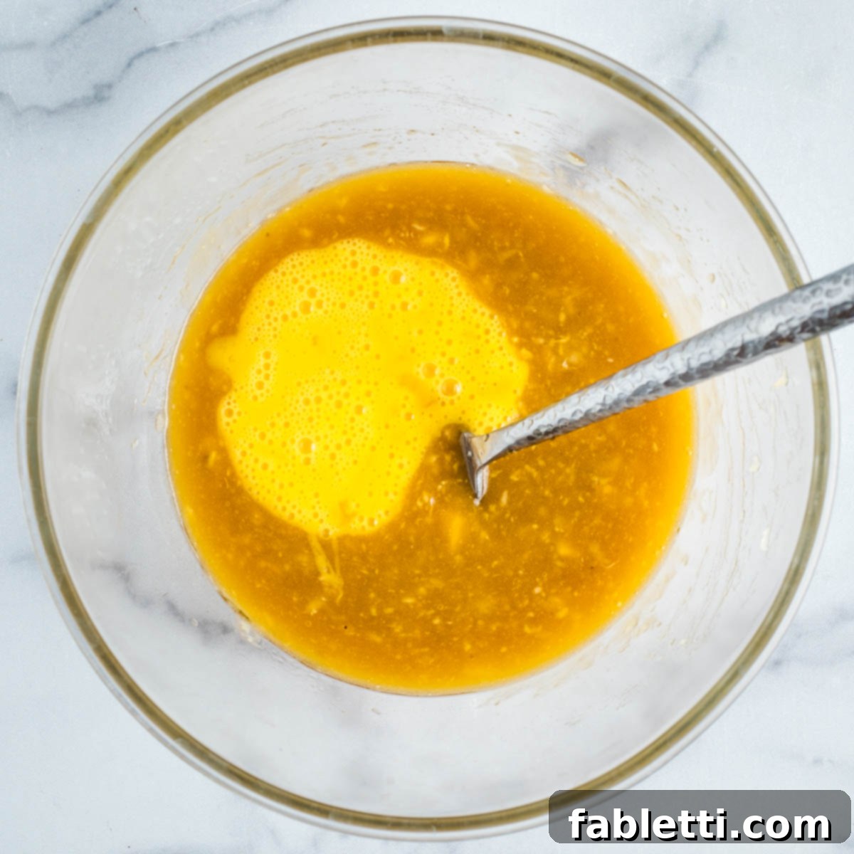 Delightful Gluten-Free Almond Carrot Muffins 7 Whisked eggs being poured into the banana and oil mixture.