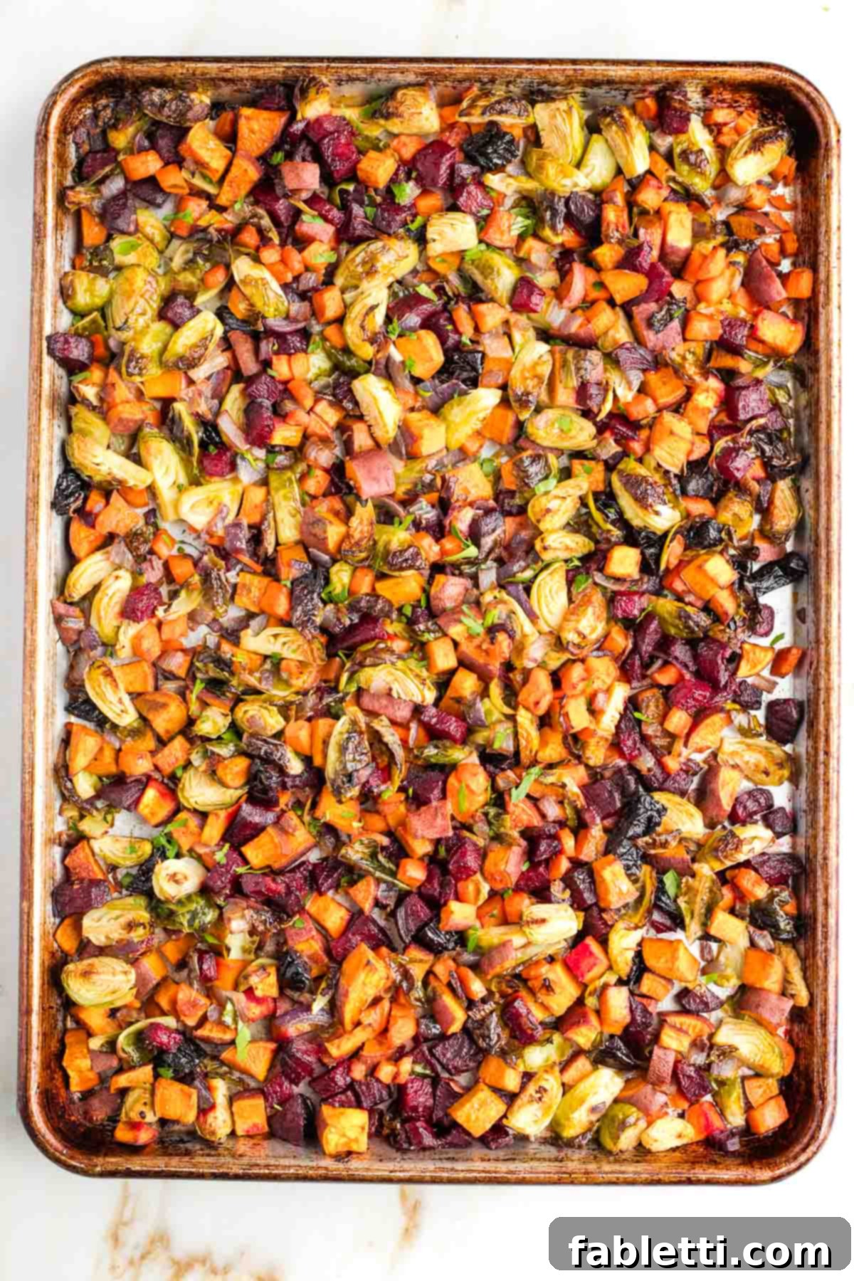 Effortless Sweet Potato and Carrot Tzimmes 7 The Tzimmes, now fully roasted and tender, with a delicious caramelization visible on the vegetables, still on the baking sheet.