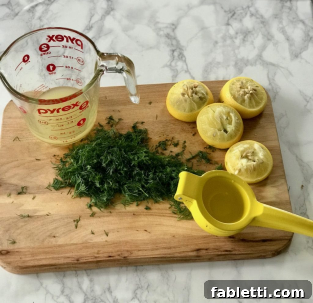 Fresh lemon and chopped dill being mixed for a homemade salad dressing