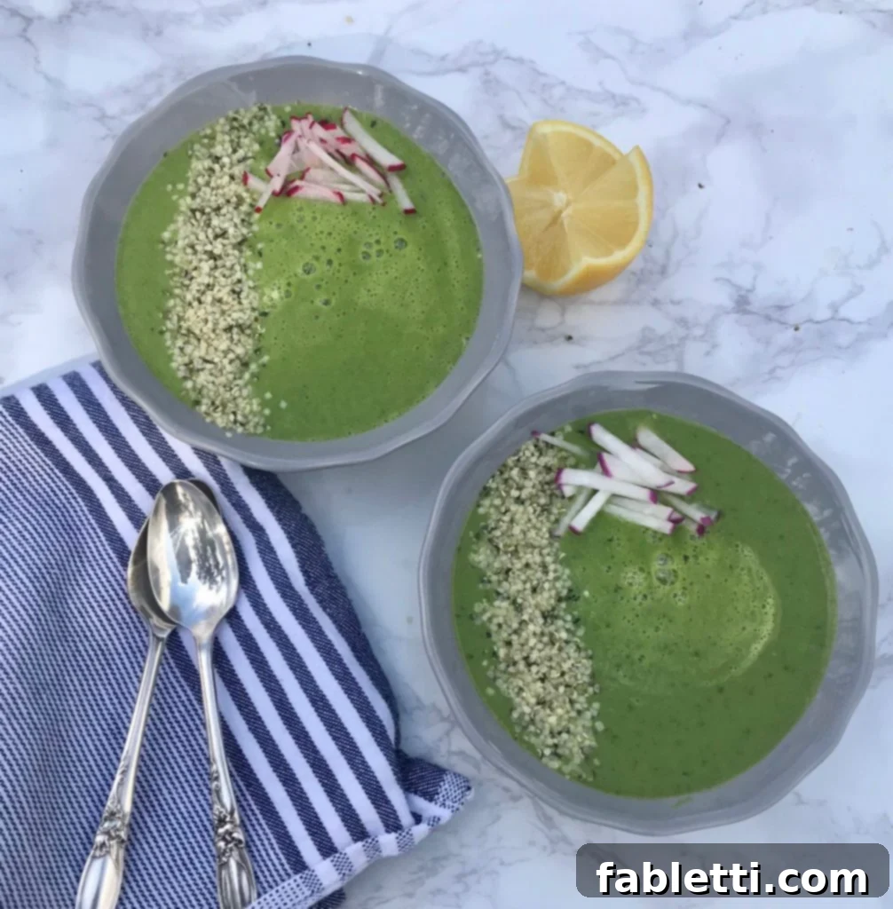 Vibrant green Spring Greens Soup in a bowl with fresh herbs and a spoon, ready to be served.