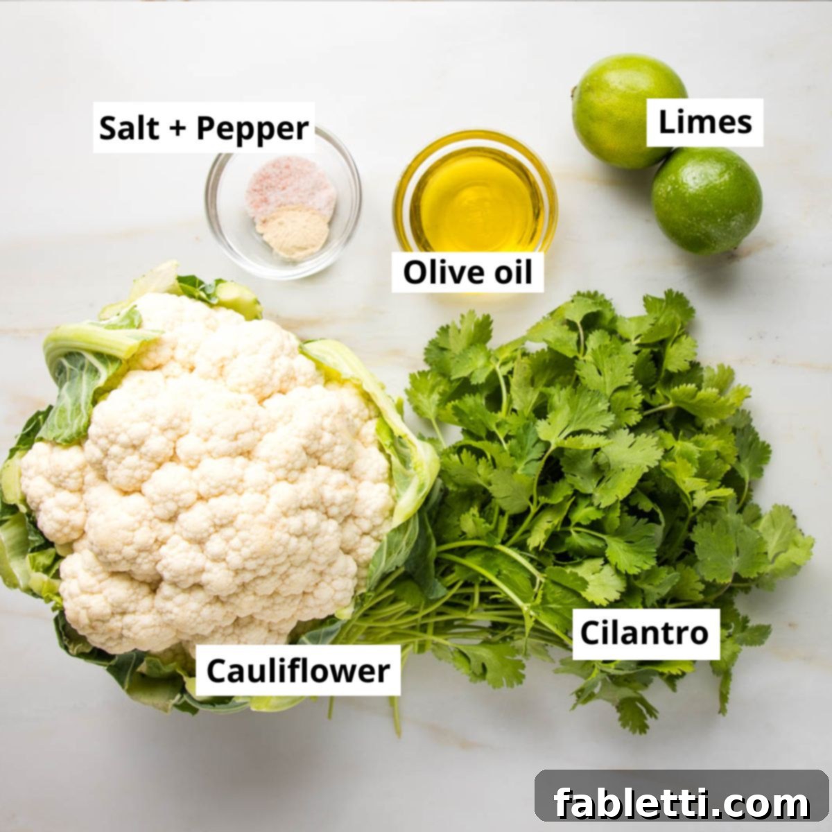 Quick Skillet Cauliflower Rice 4 Labeled ingredients for simple cauliflower rice: Cauliflower, cilantro, olive oil, salt + pepper, limes.