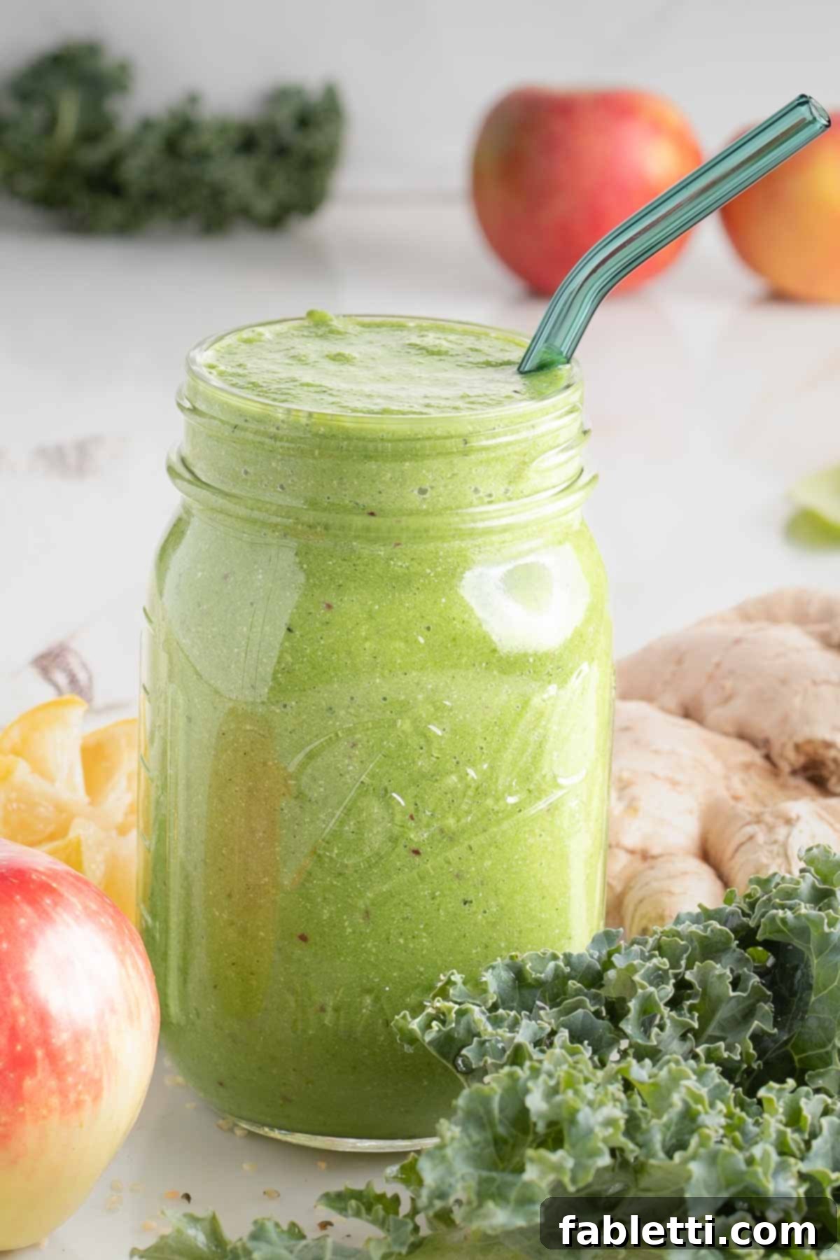 Avocado Kale Superfood Smoothie 9 A beautifully composed flat lay of fresh, colorful smoothie ingredients: vibrant kale, spinach, and a bright green apple, alongside creamy avocado, zesty lemon, pungent ginger, and nutritious hemp seeds, artfully arranged on a light surface.