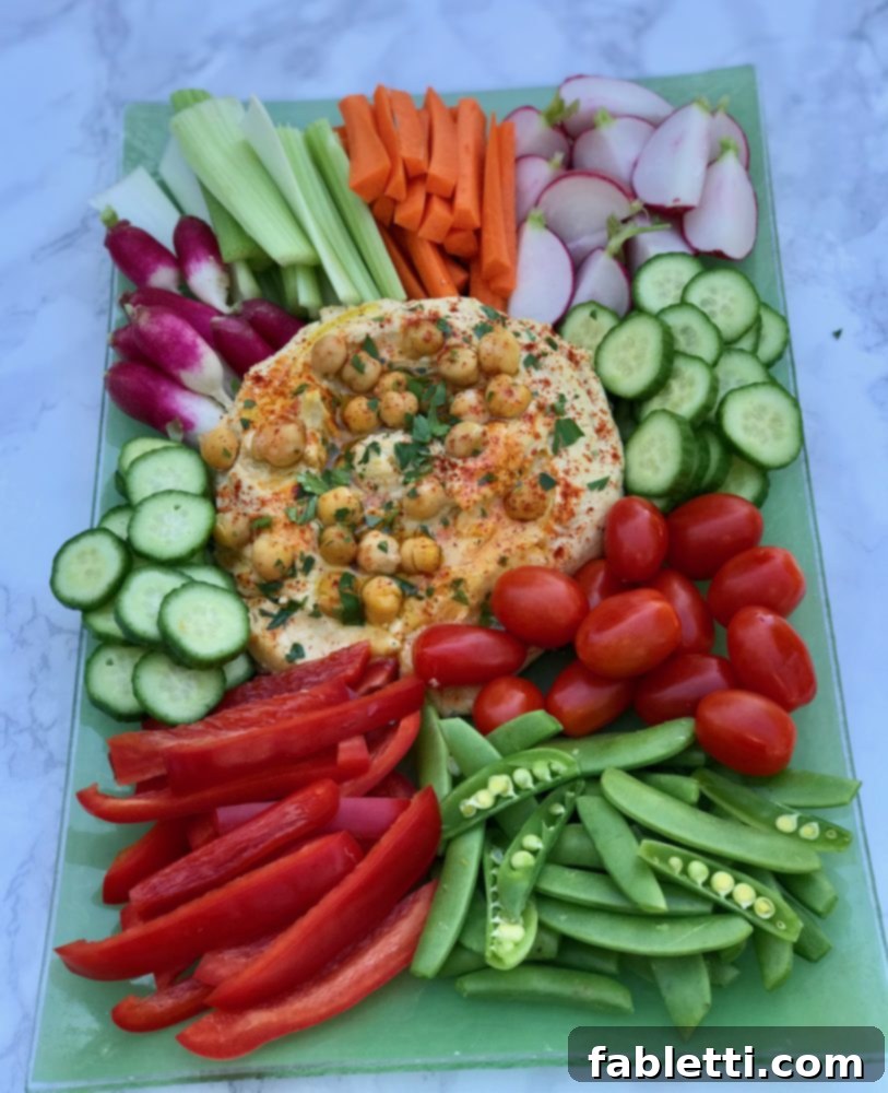 Healthy homemade oil-free hummus in a bowl, garnished with fresh herbs and a sprinkle of paprika.