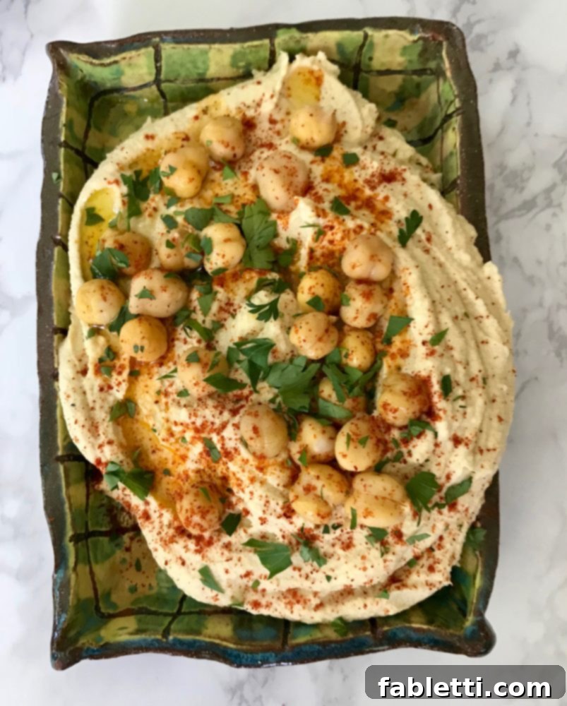 Freshly made hummus served with colorful raw vegetables like carrots, cucumbers, and bell peppers.