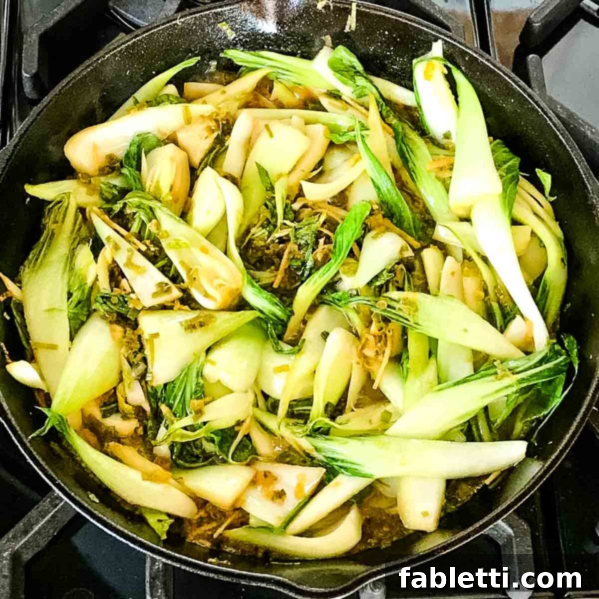 Aromatic Ginger Scallion Baby Bok Choy 6 Cast iron skillet with cooked bok choy and garlic and ginger.