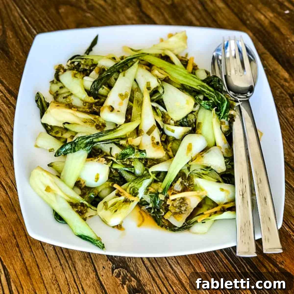Aromatic Ginger Scallion Baby Bok Choy 7 Cooked baby bok choy arranged attractively on a plate.