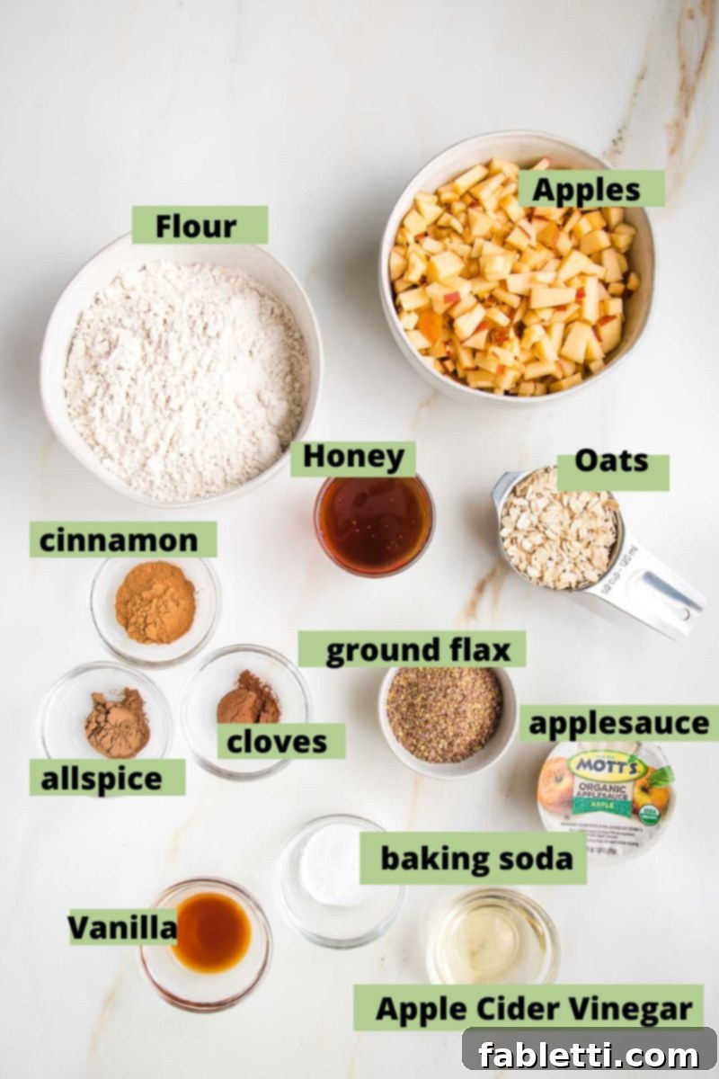 Spiced Apple Bundt Delight 3 Labeled ingredients for apple cake recipe: flour, apples, oats, honey, cinnamon, allspice, cloves, ground flax, apple sauce, vanilla, baking soda, apple cider vinegar.