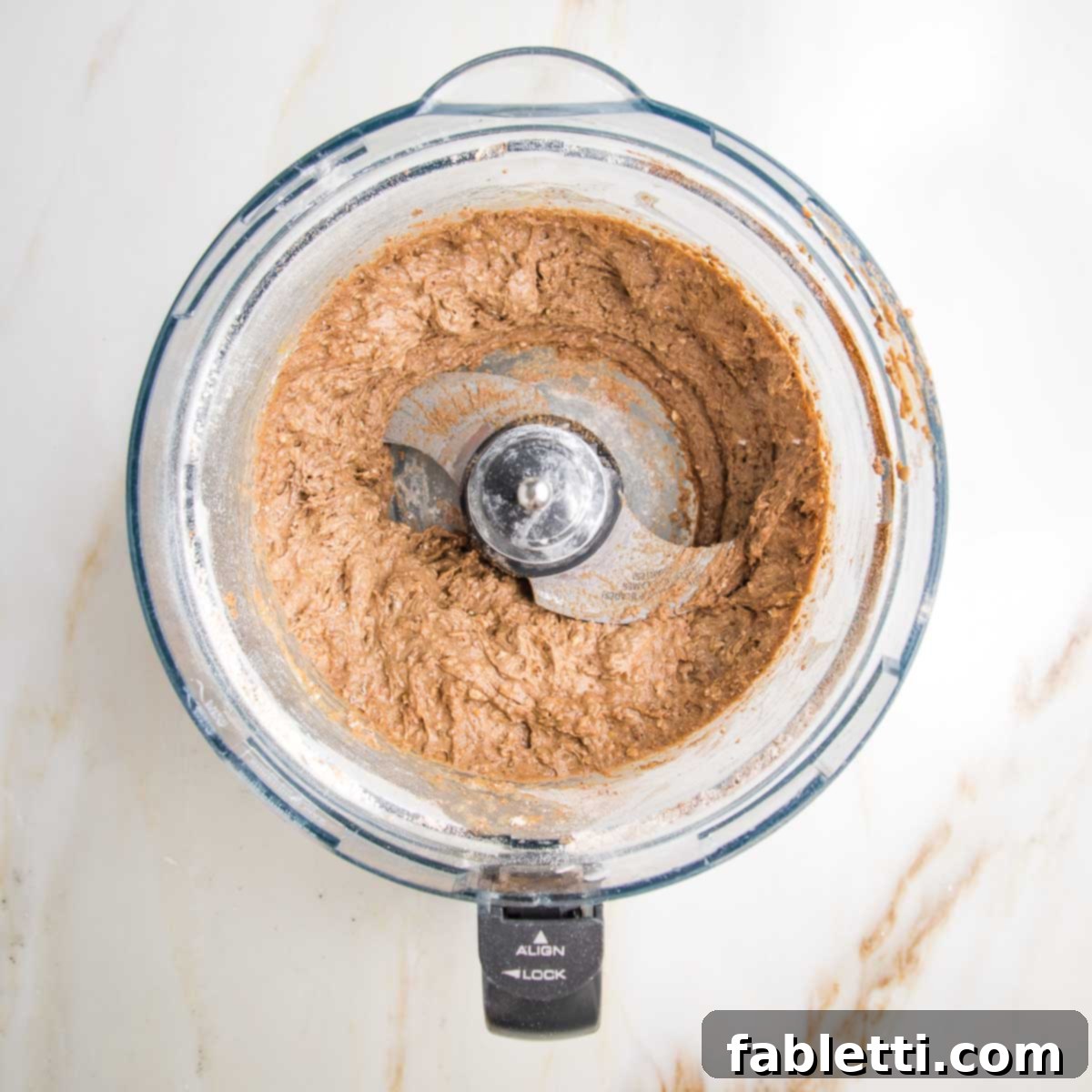 Spiced Apple Bundt Delight 6 Cake batter in the bowl of a food processor with the "s" blade.