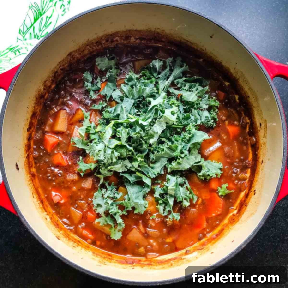 After initial baking, removing the stew from the oven and stirring to check tenderness.