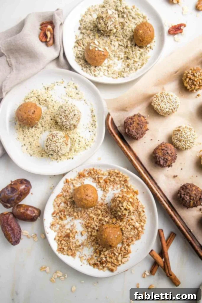 Pumpkin Spice Truffles 11 Several white plates each holding pumpkin balls being rolled in different crushed nuts or seeds. In the background, a parchment-lined tray displays an assortment of finished pumpkin spice balls, each with a unique coating.