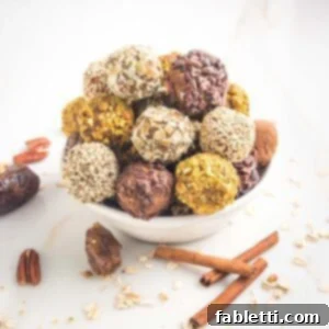 Pumpkin Spice Truffles 14 A white bowl showcasing a neat stack of pumpkin energy balls, each adorned with distinct crushed nut and seed coatings. The foreground is arranged with natural elements like dates, rolled oats, cinnamon sticks, and whole pecans.