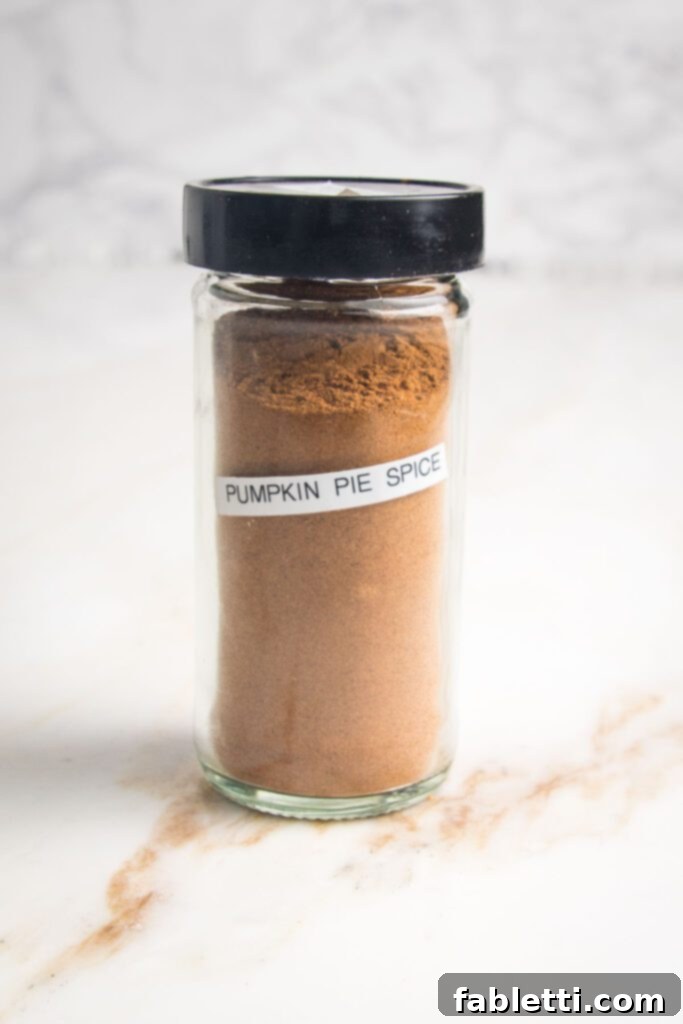 Pumpkin Spice Truffles 6 A small, elegantly labeled jar with a black lid, filled with a rich brownish spice mixture and clearly marked "Pumpkin Pie Spice".