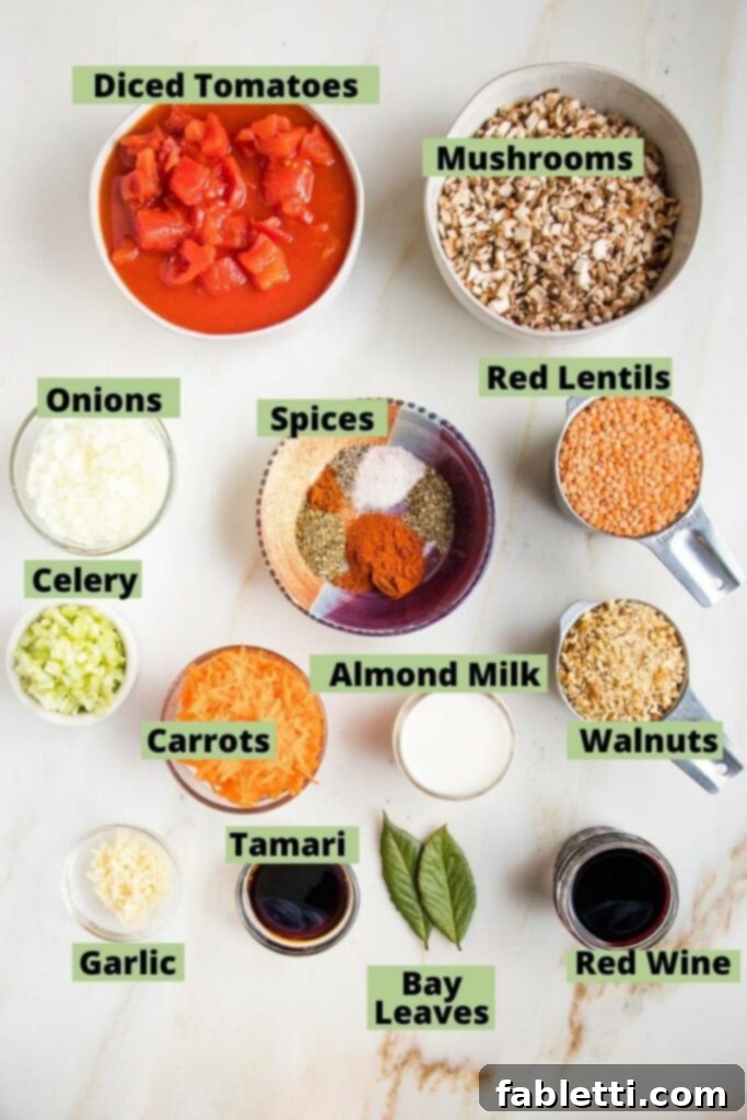 Hearty Vegan Bolognese over Squash Strands 3 A selection of fresh and pantry ingredients for Vegan Bolognese, including diced tomatoes, various mushrooms, onions, celery, garlic, shredded carrots, red lentils, almond milk, chopped walnuts, assorted spices, red wine, tamari, and bay leaves, all neatly arranged.