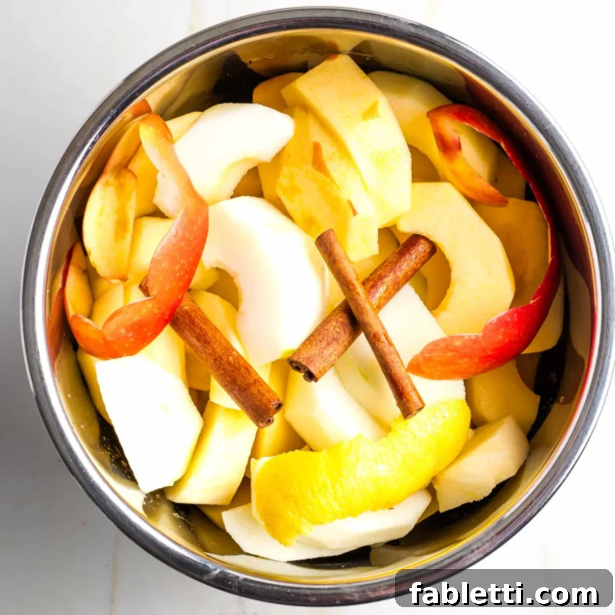 Apples, lemon, and cinnamon in an Instant Pot before cooking.