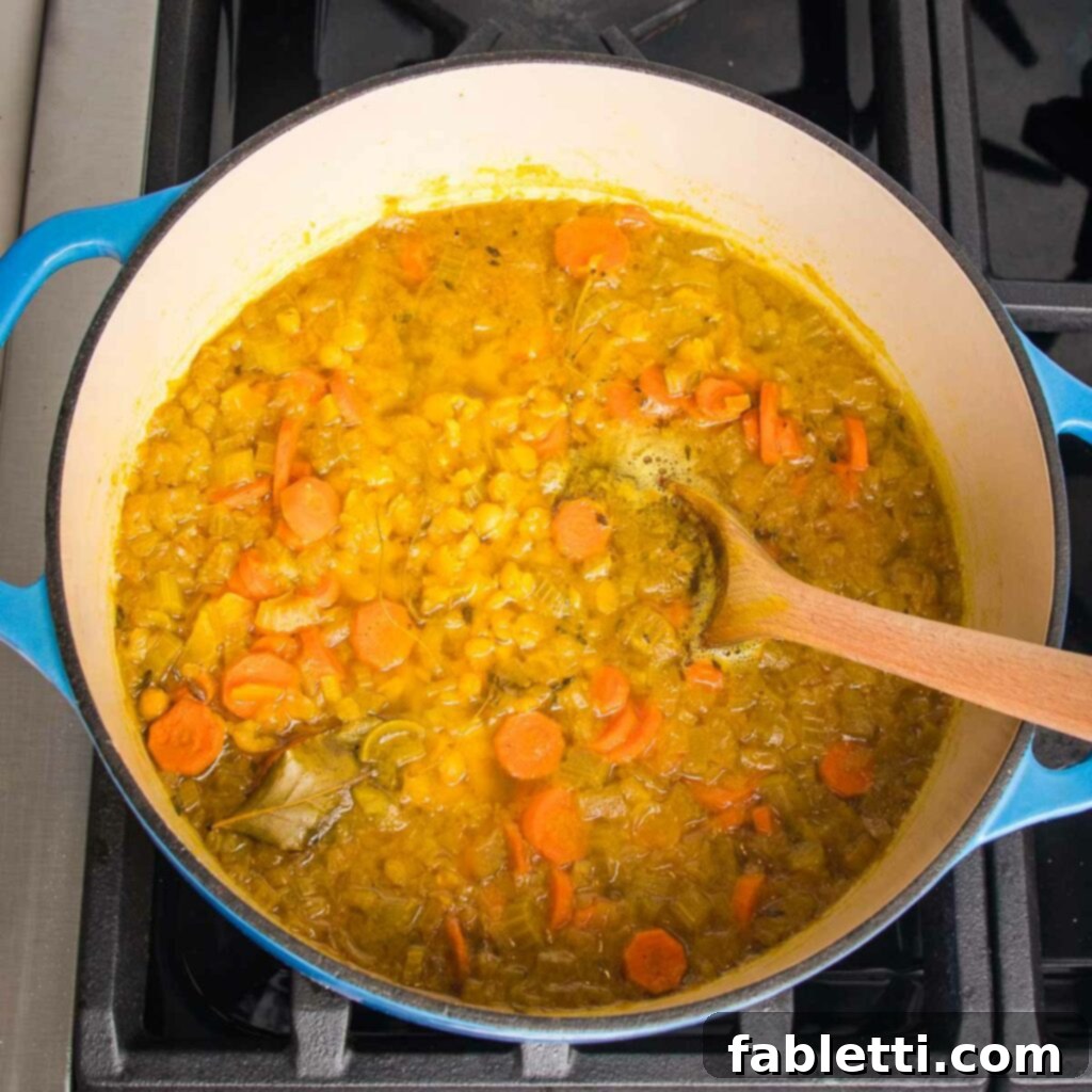Hearty Vegan Yellow Split Pea Soup 11 The soup simmering on the stovetop until the split peas are tender.