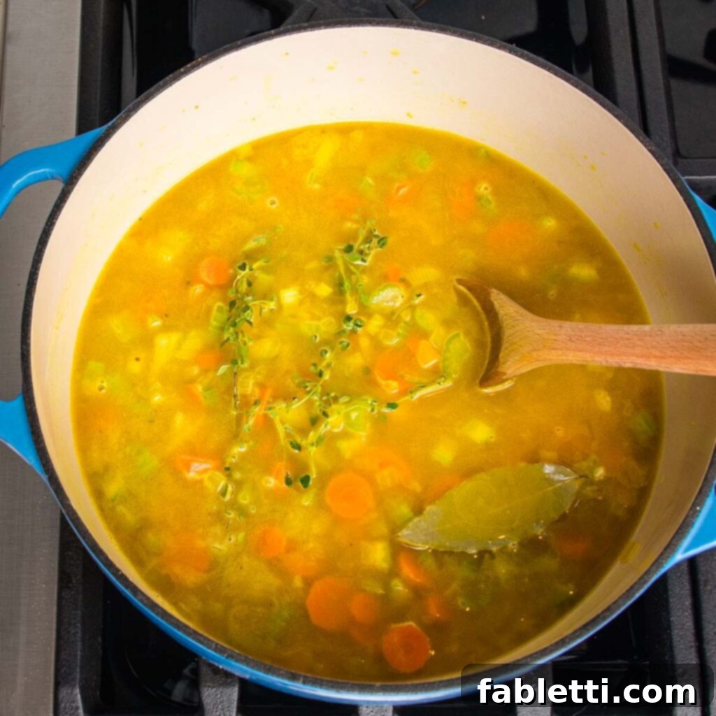 Hearty Vegan Yellow Split Pea Soup 10 Ingredients being mixed well in the pot, creating a flavorful base.