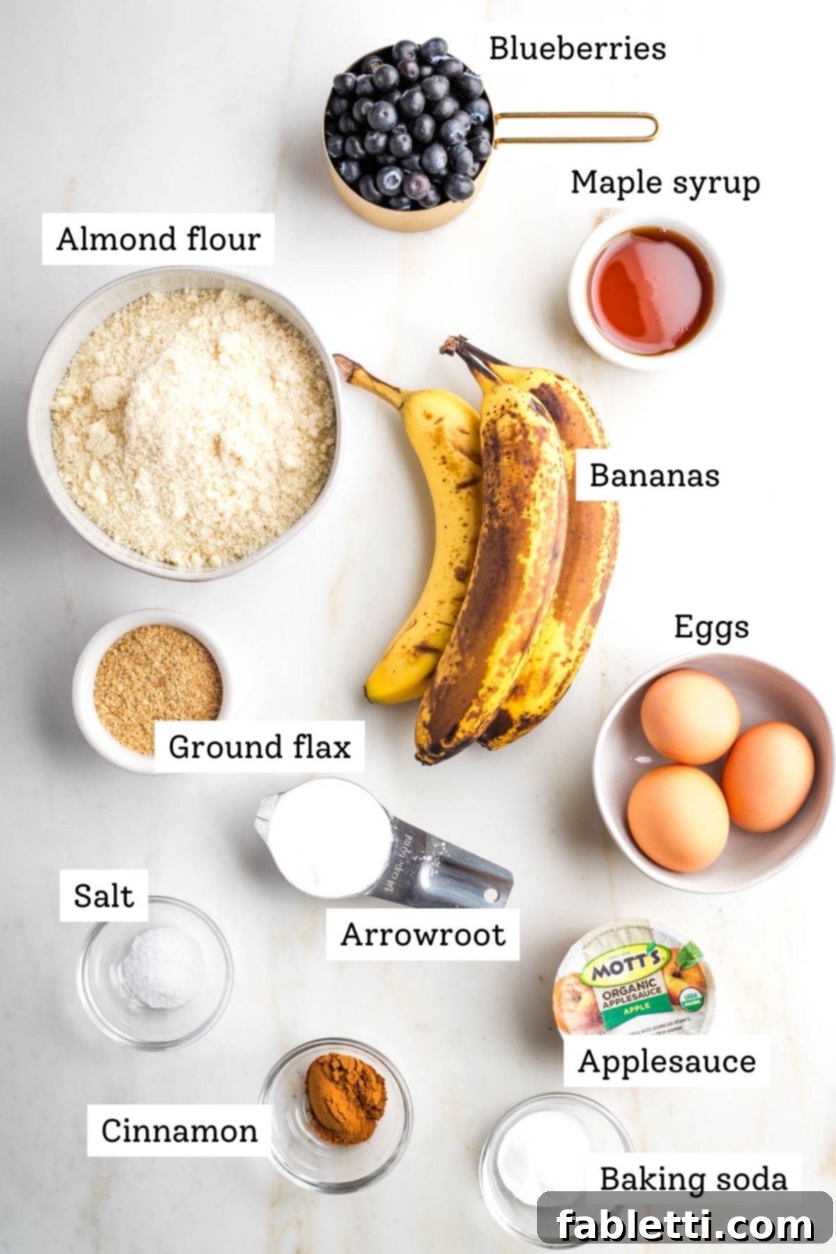 Quick Blender Almond Blueberry Muffins 3 A selection of ingredients for blueberry muffins: blueberries, almond flour, ripe bananas, eggs, ground flaxseed, cinnamon, arrowroot powder, applesauce, and baking soda.