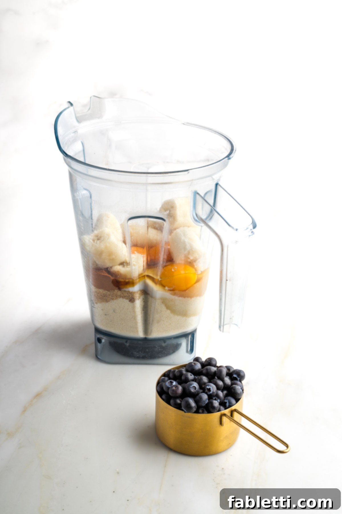 Quick Blender Almond Blueberry Muffins 5 All the dry and wet ingredients for almond flour muffins, excluding blueberries, placed in a blender pitcher ready for blending.