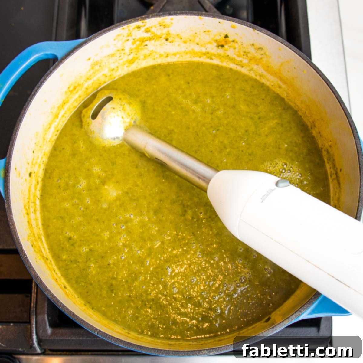 Nourishing Parsnip and Kale Soup 16 Immersion blender inside a Dutch oven pureeing green vegetable soup.