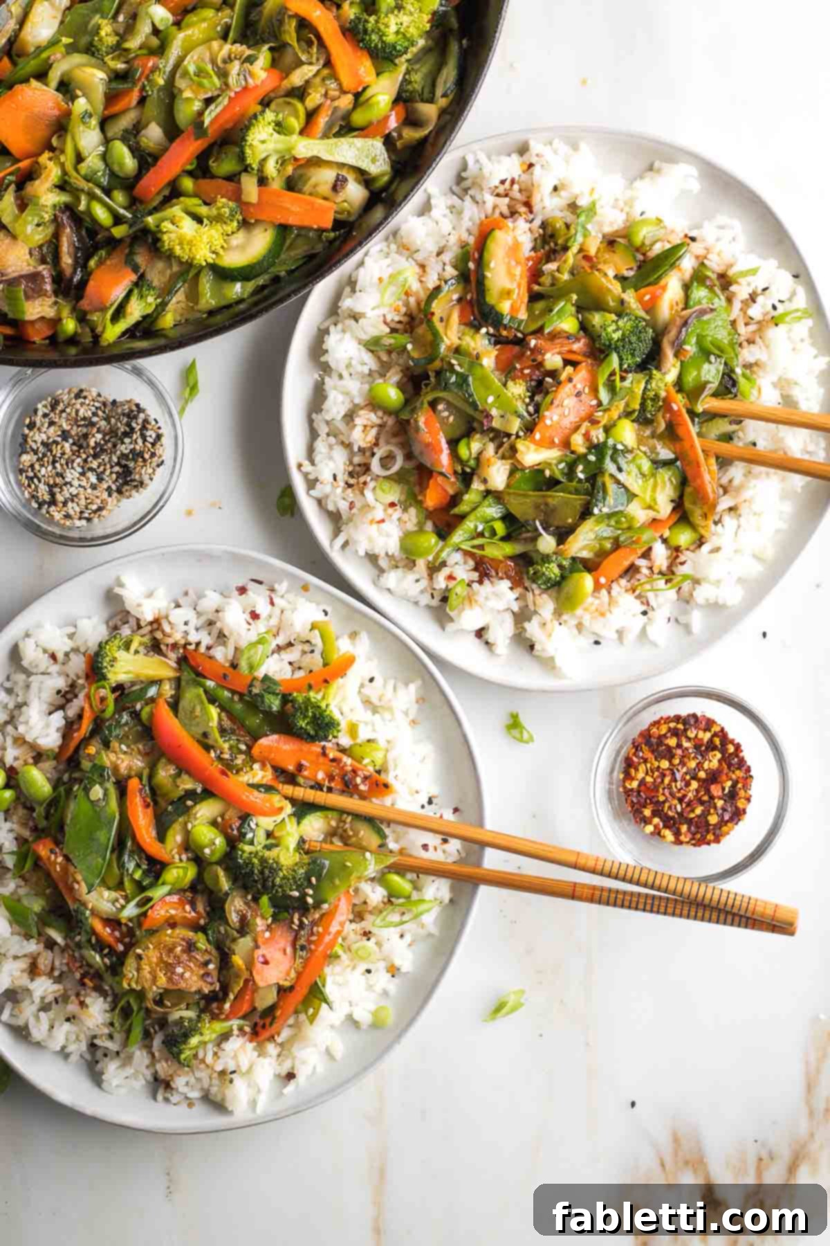 Quick and Flavorful Teriyaki Vegetable Stir-Fry 2 Two plates of rice topped with stir fried vegetables with teriyaki sauce.