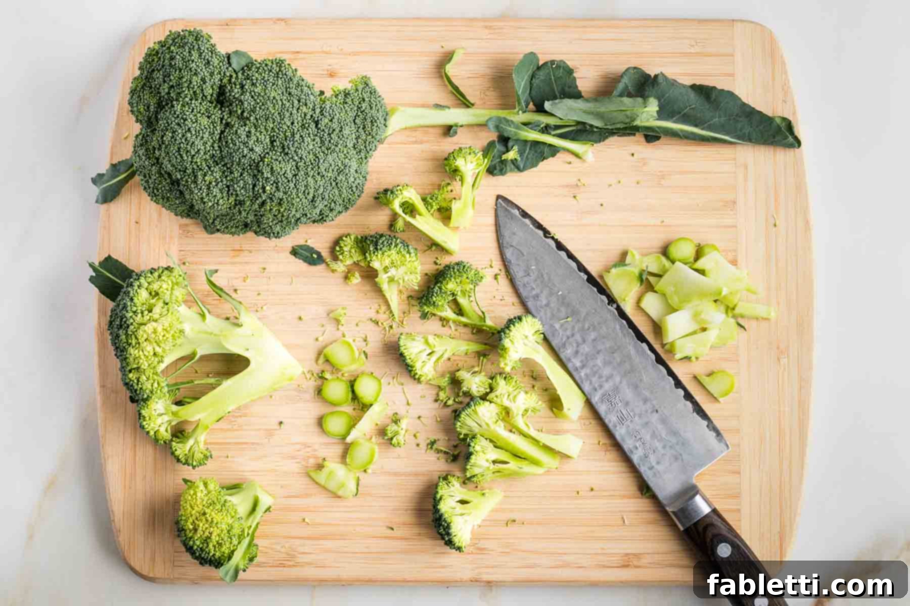 Quick and Flavorful Teriyaki Vegetable Stir-Fry 7 Chef's knife cutting broccoli stems into discs and crowns into florets.