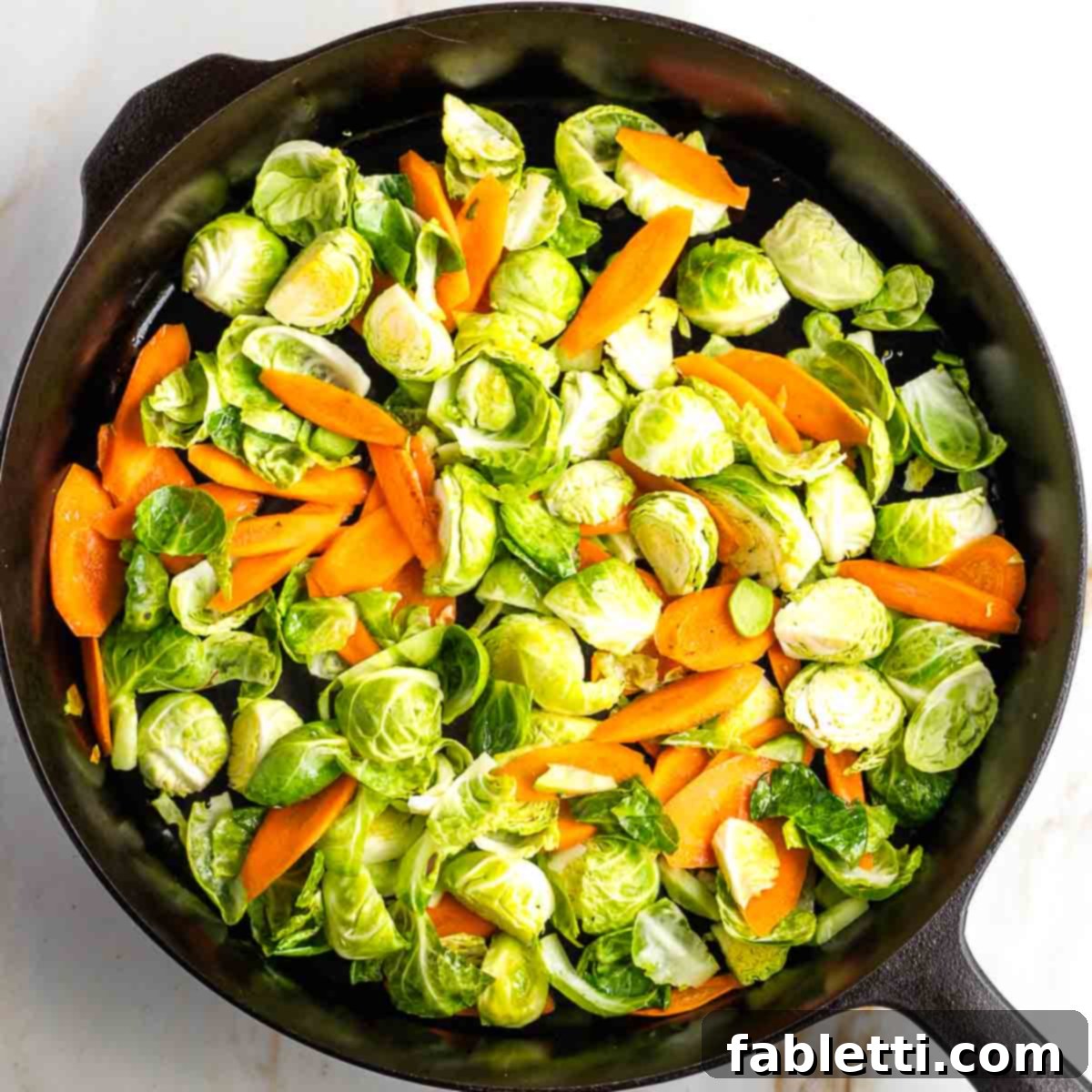 Quick and Flavorful Teriyaki Vegetable Stir-Fry 10 Carrots, Brussels sprouts, and broccoli stems cooking in a large pan with oil.