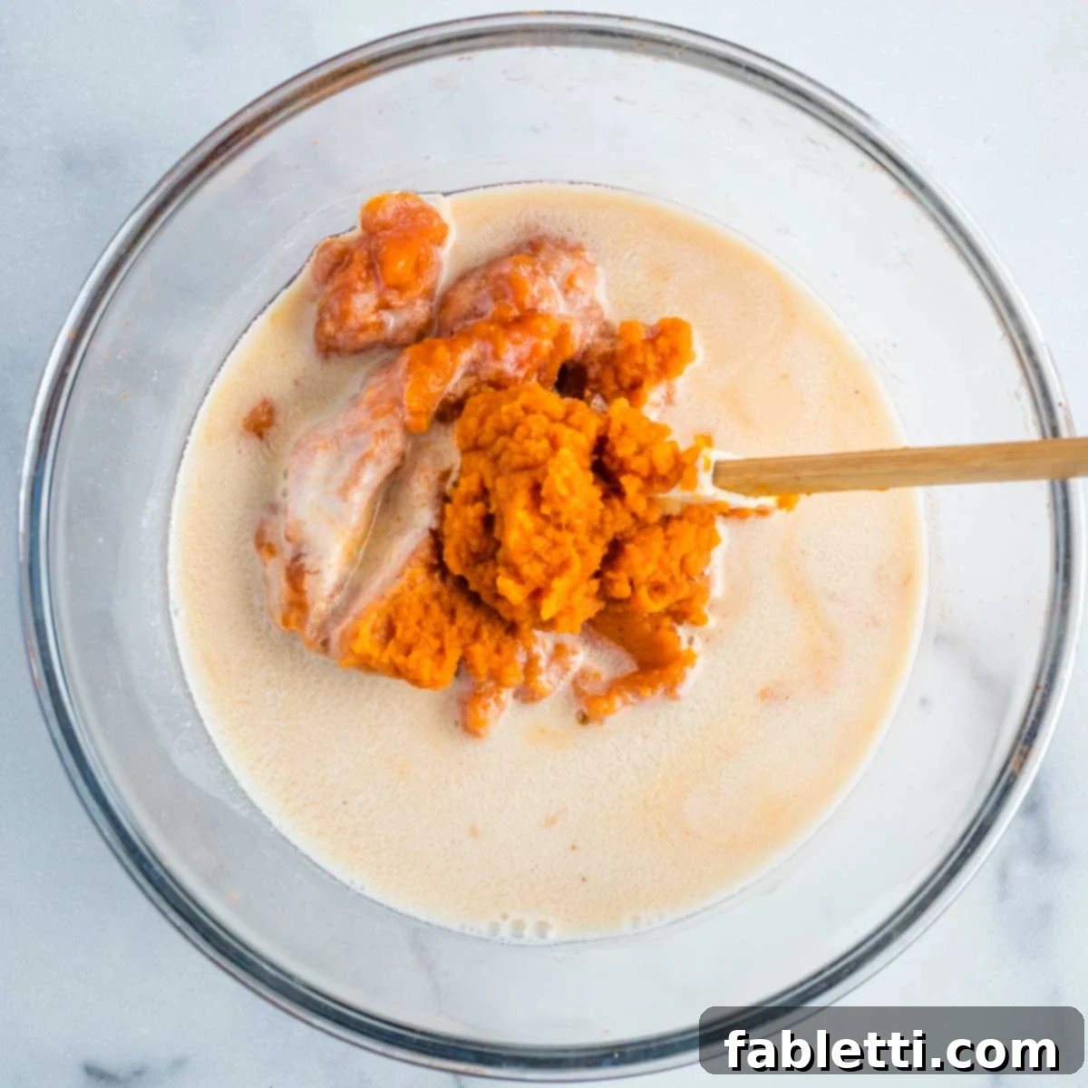 Decadent Vegan Double Chocolate Flax Muffins 6 Wet ingredients for muffins: pumpkin puree, applesauce, maple syrup, and almond milk in a glass bowl, before mixing.