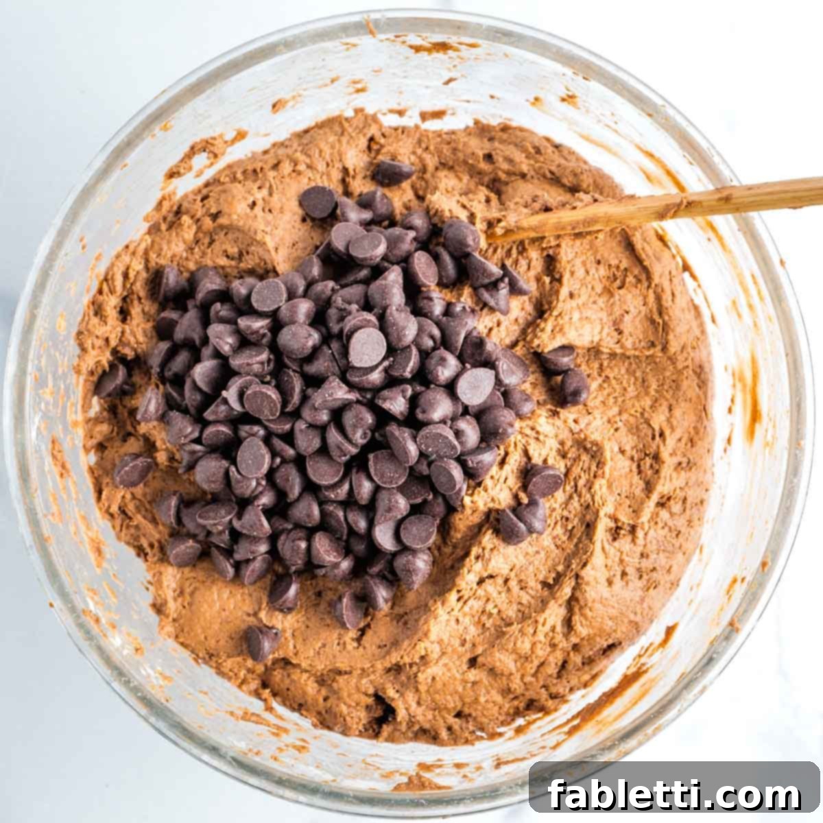 Decadent Vegan Double Chocolate Flax Muffins 9 Chocolate muffin batter with dark chocolate chips folded in, in a glass mixing bowl.