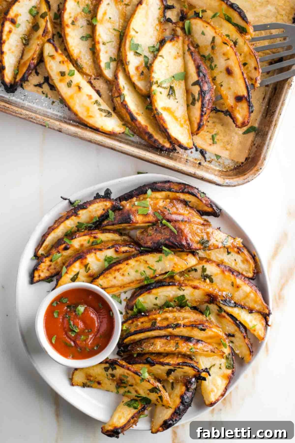 Golden Miso Crunch Potatoes 2 Crispy potato wedges on a plate with some ketchup, sprinkled with fresh herbs.