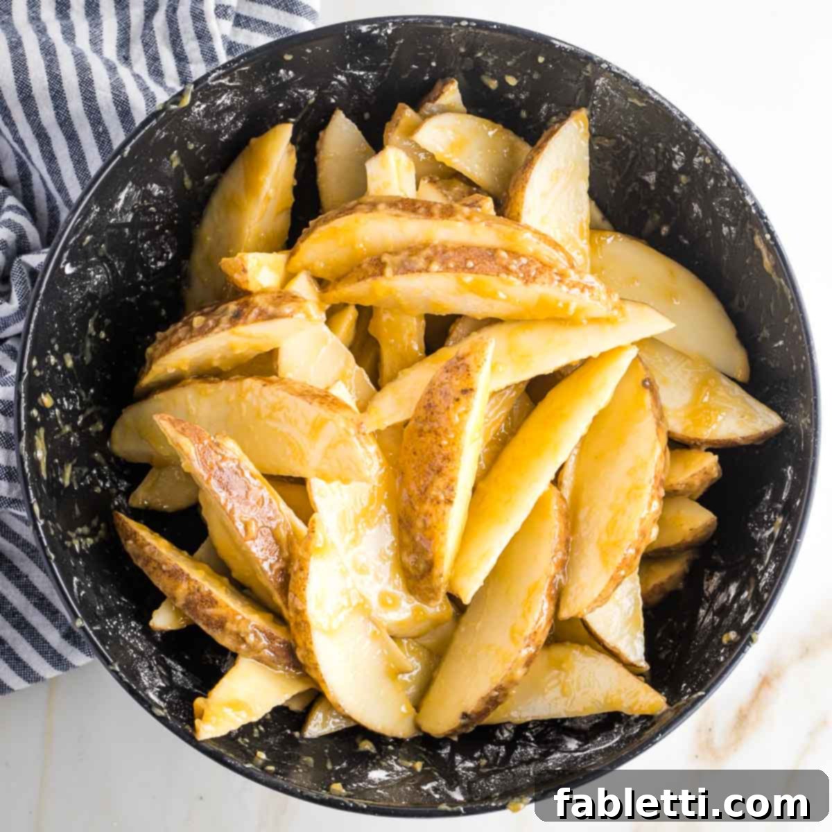 Golden Miso Crunch Potatoes 12 Potato wedges in a bowl with brown marinade.