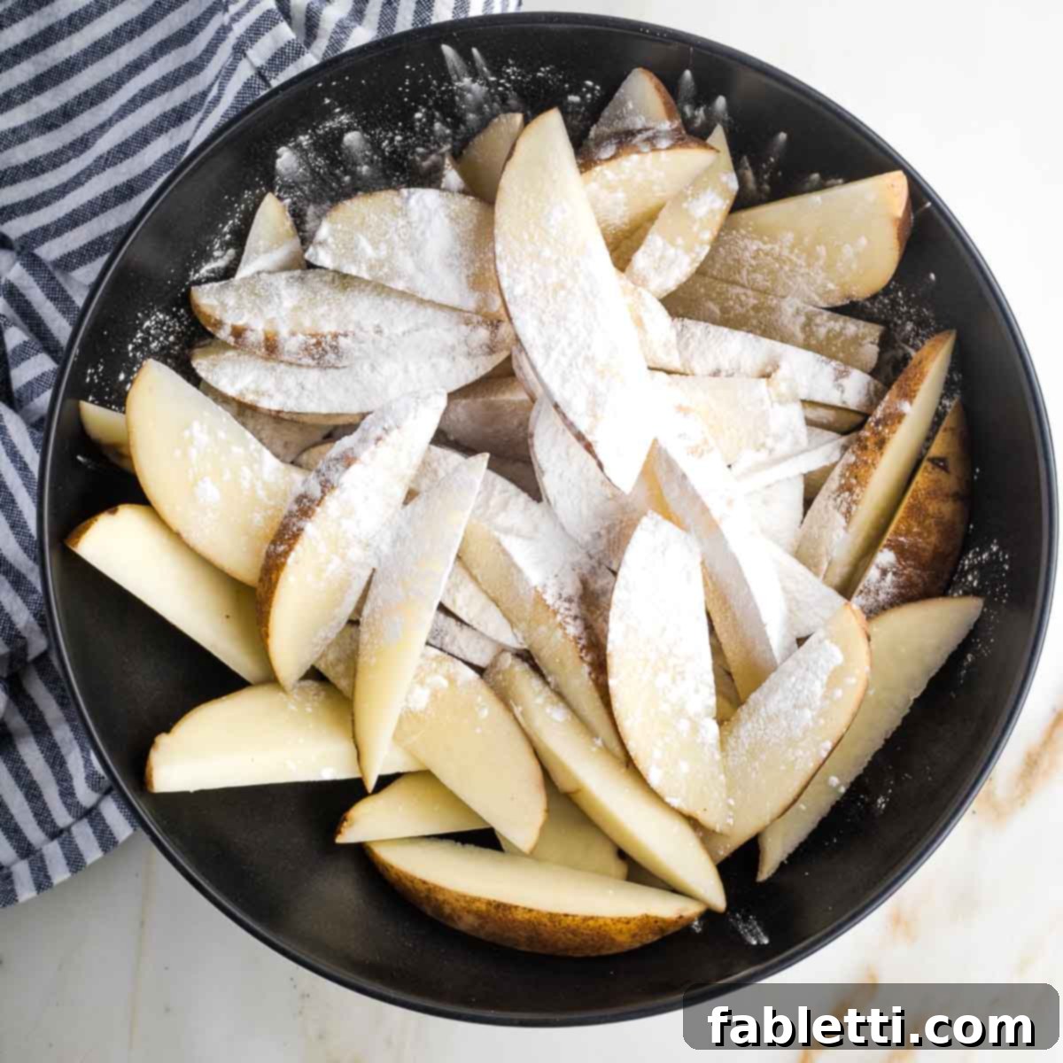 Golden Miso Crunch Potatoes 9 Bowl of potato wedges sprinkled with white powder.