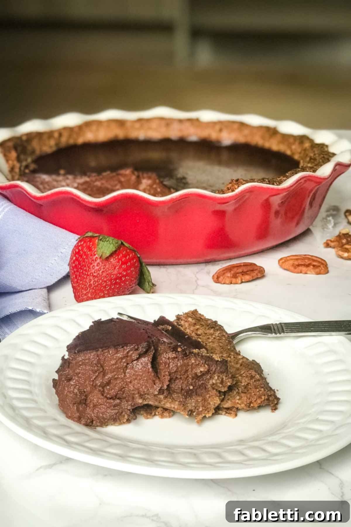 Guilt-Free Chocolate Pudding Pie 3 A close-up side view of a generous slice of healthy chocolate pudding pie, with the full pie subtly blurred in the background, highlighting its rich texture.