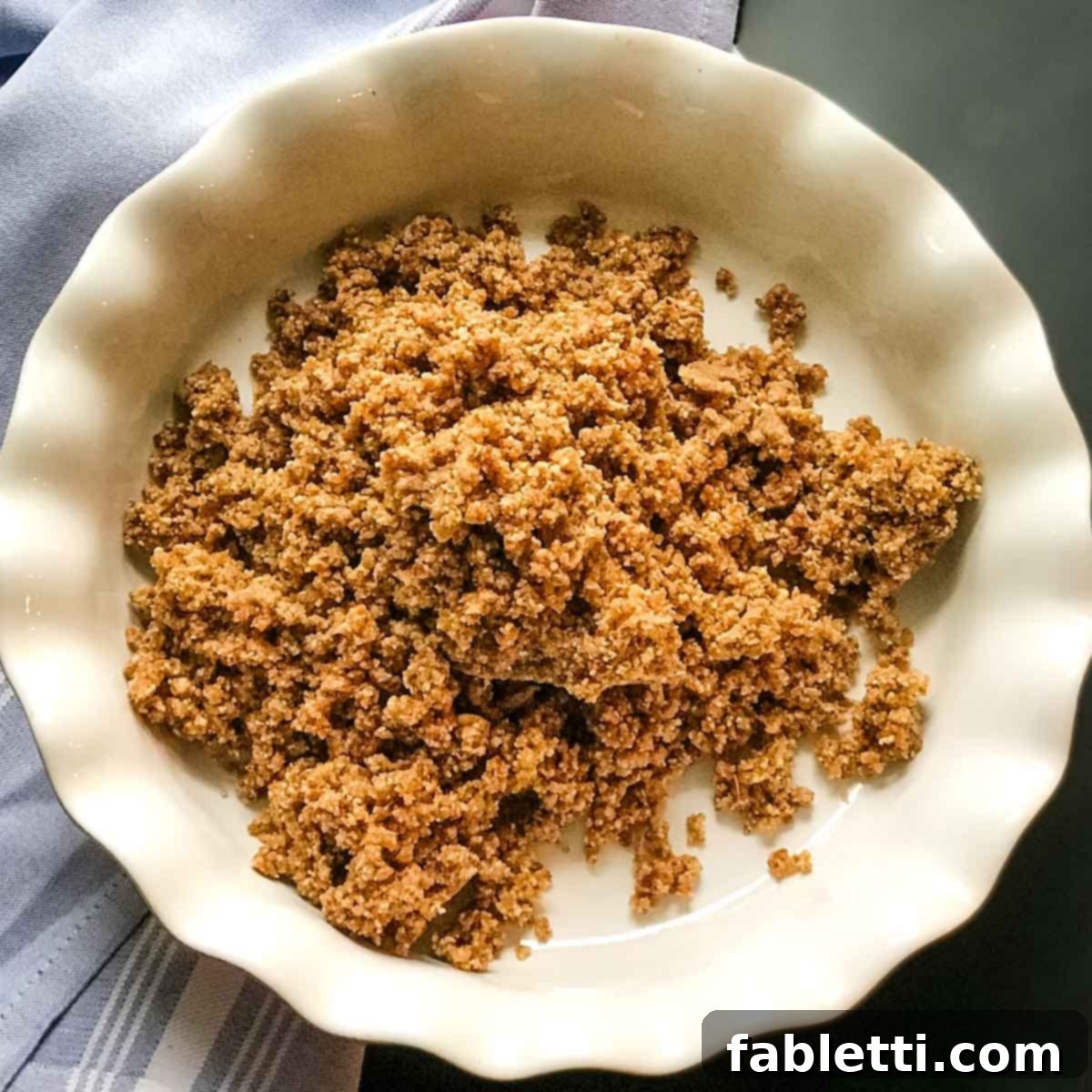 Guilt-Free Chocolate Pudding Pie 6 The date and nut crumb mixture heaped in the center of a ceramic pie dish, ready for pressing.