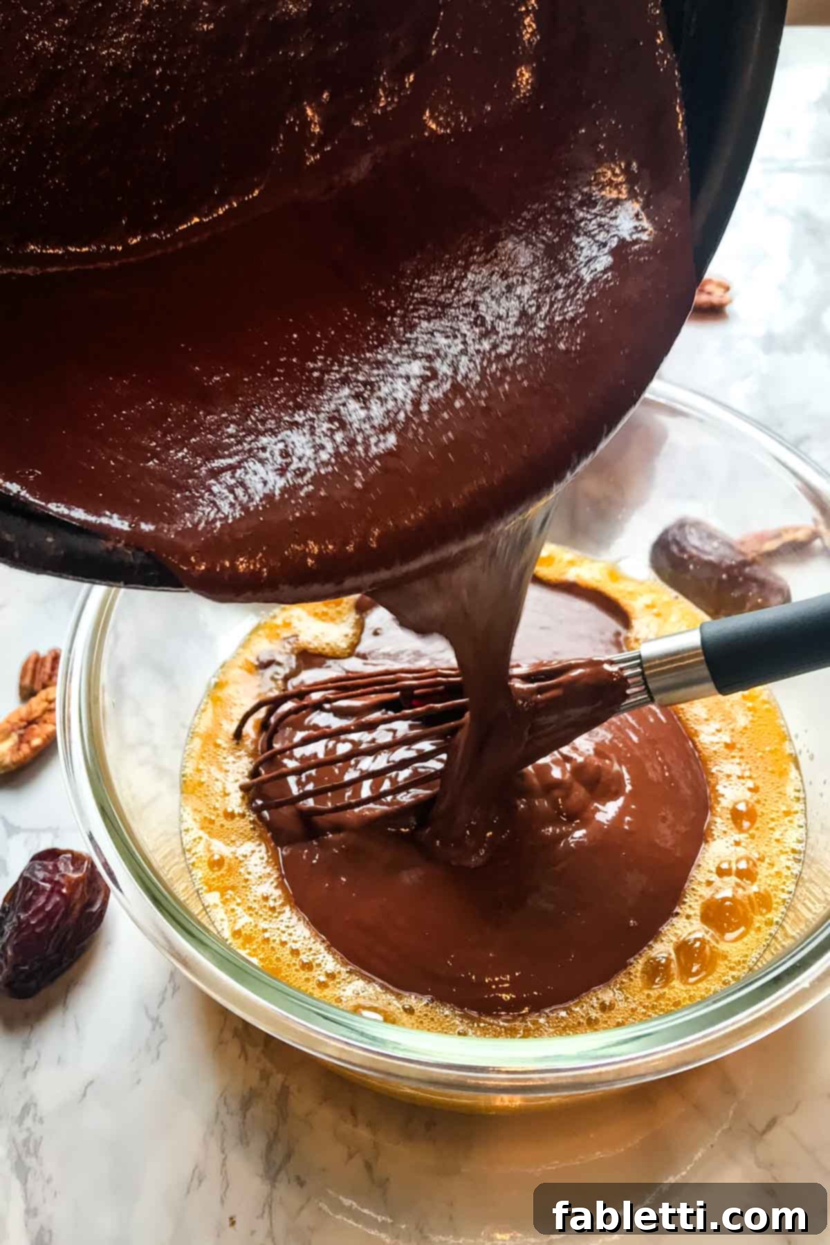 Guilt-Free Chocolate Pudding Pie 8 A visual step demonstrating pouring melted chocolate mixture into whisked eggs in a bowl, crucial for tempering.