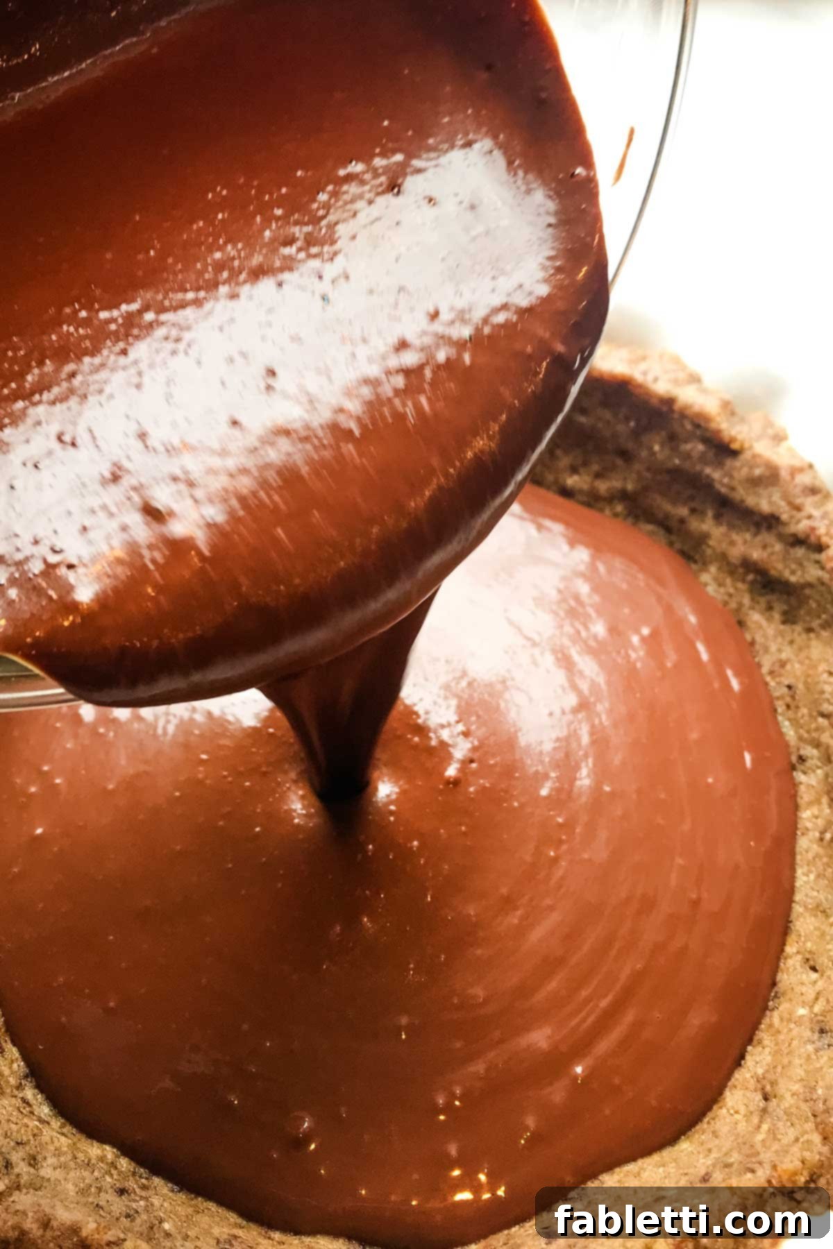 Guilt-Free Chocolate Pudding Pie 9 The smooth chocolate and egg mixture being carefully poured into the pre-made nut pie crust, ready for baking.