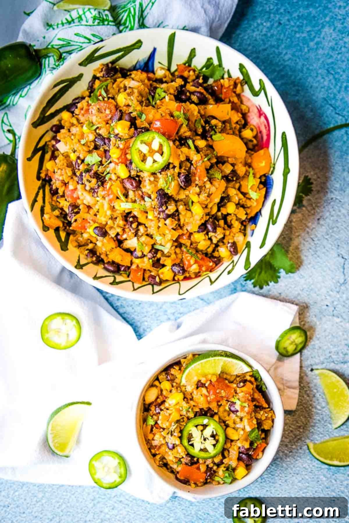 Flavorful Low Carb Mexican Cauliflower Rice 6 A bowl of vibrant Mexican style cauliflower rice, artfully garnished with fresh jalapeño slices and bright lime wedges, showcasing its healthy and delicious appeal.