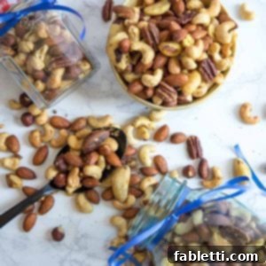 Assorted spiced nuts spilling out of ribboned jars and also in a bowl.