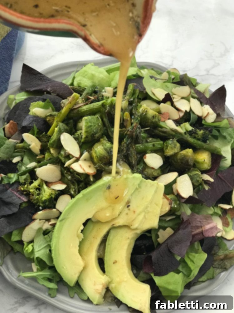 Effortless Everyday Salad Dressing 6 A vibrant and healthy salad bowl featuring fresh greens, sliced avocado, an assortment of nuts, and various colorful vegetables, ready to be dressed.