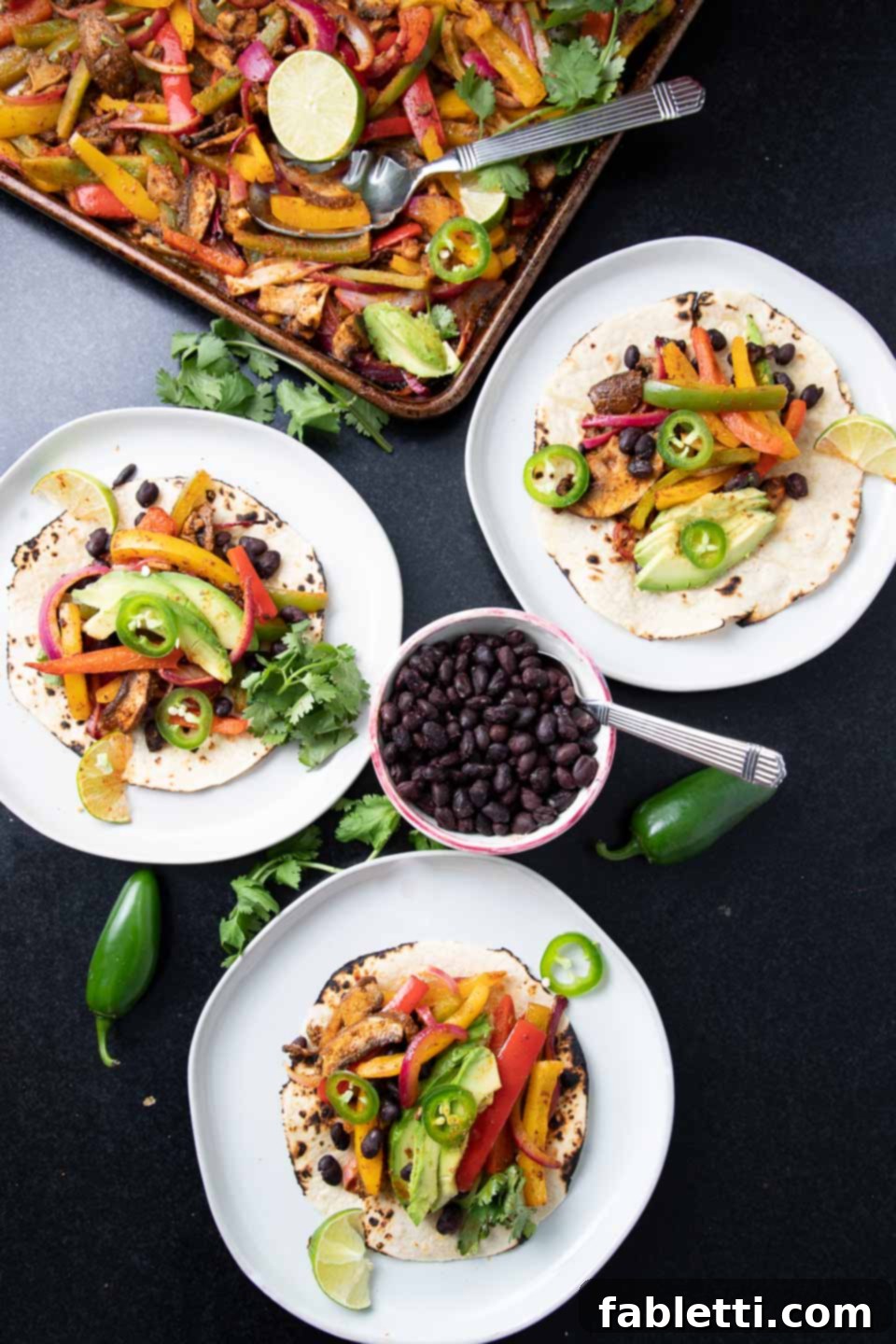Roasted veggies on top of tortillas with bean and avocado