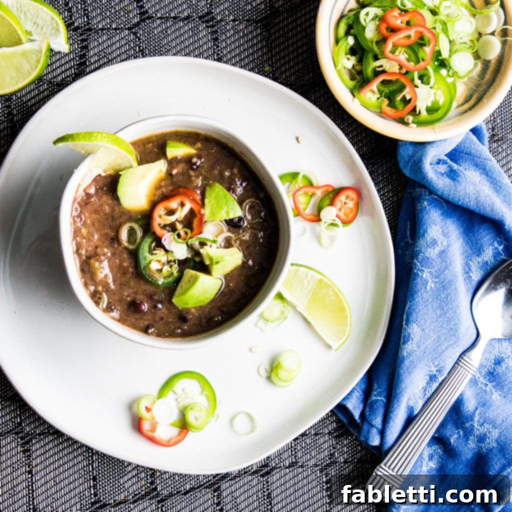 No-Fuss Black Bean Soup 2 Rich black bean soup garnished with fresh lime wedges, vibrant sliced jalapenos, crisp green scallions, and crunchy tortilla chips. A perfect blend of flavors and textures.