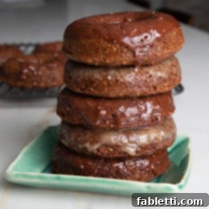 Gluten-Free Baked Pumpkin Spice Doughnuts 11 Pile of pumpkin donuts with maple or chocolate glaze dripping down.