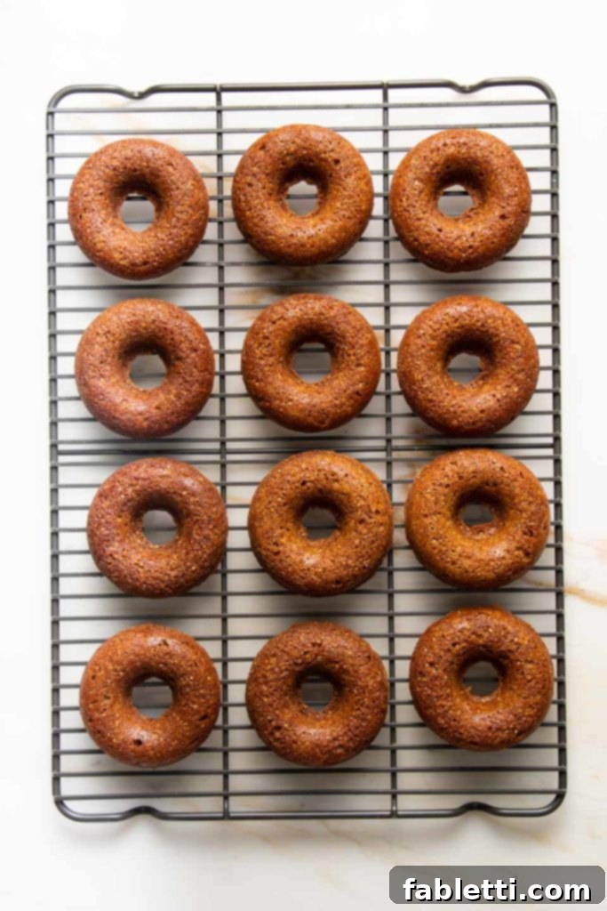 Gluten-Free Baked Pumpkin Spice Doughnuts 5 Baked pumpkin donuts cooling on a wire rack after being removed from the pan.