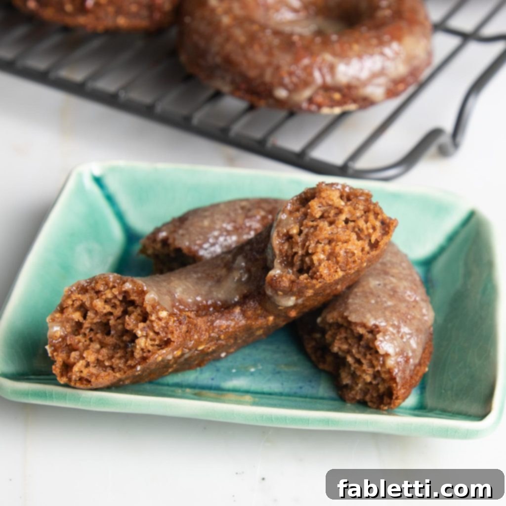 Gluten-Free Baked Pumpkin Spice Doughnuts 10 Beautiful orange colored pumpkin donut with a maple glaze, showcasing its vibrant hue and delicate topping.